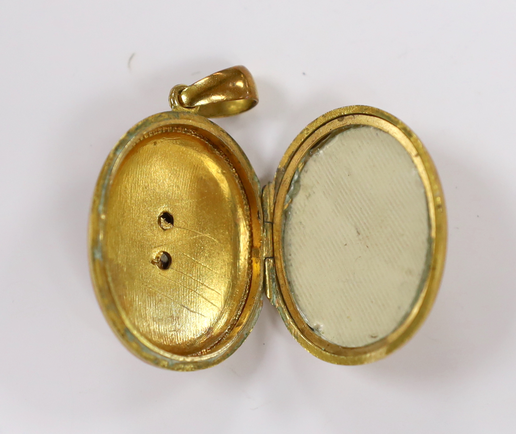 An early 20th century gilt metal and blue enamel set oval locket, with floral motif, overall 48mm, gross weight 17.3 grams.